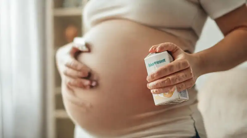 Mujer embarazada con leche almendrada, calma